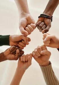 Hands of diverse people fist bumping, symbolizing unity and teamwork.