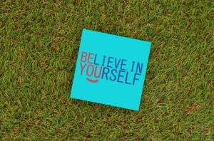 A vibrant note saying 'Believe in Yourself' placed on green turf, capturing motivation and optimism.