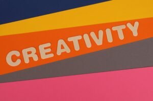 Vibrant layered paper design featuring the word 'Creativity' in bold letters.